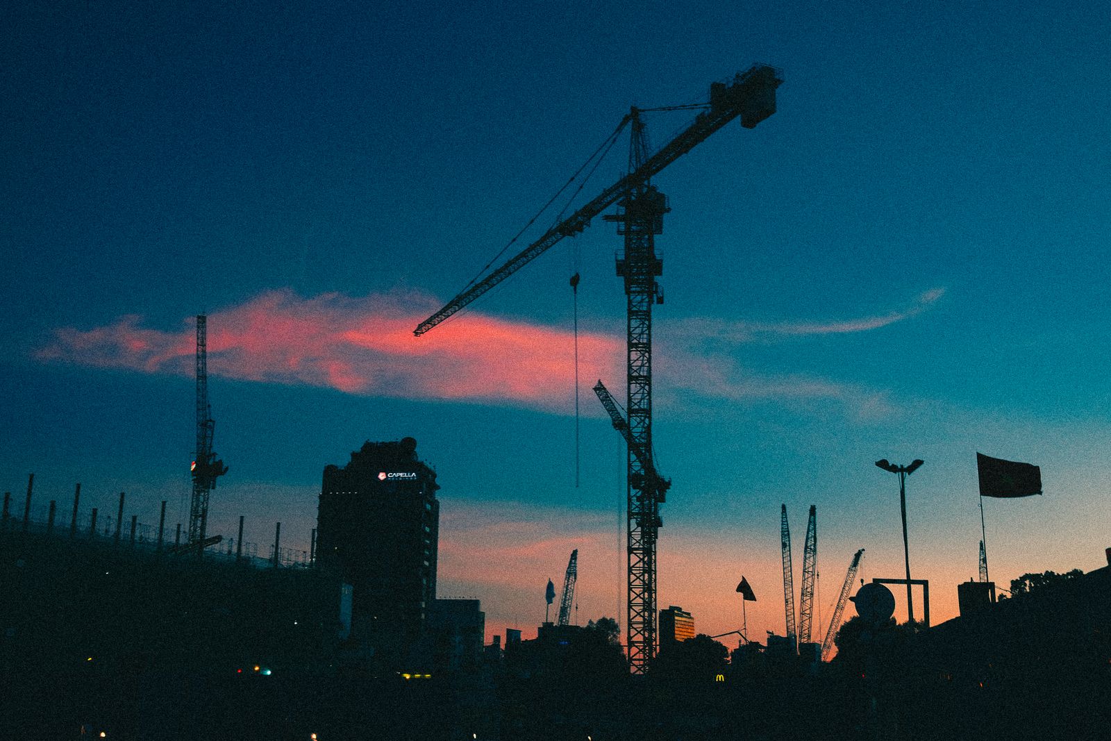 Construction cranes over new residential buildings at dusk